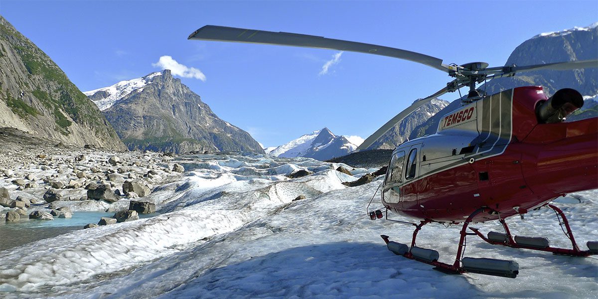 A helicopter is parked on the side of a mountain.