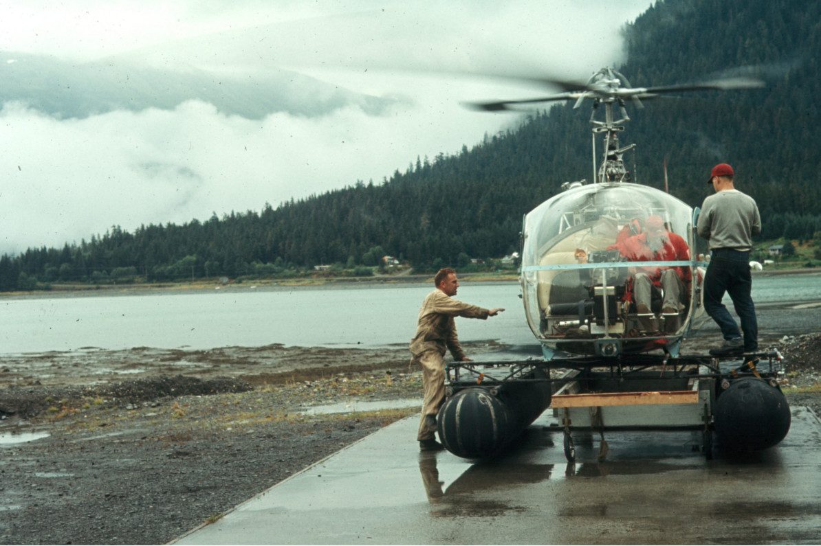 A helicopter is being worked on by someone.