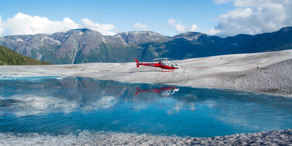 A helicopter is being worked on by someone.