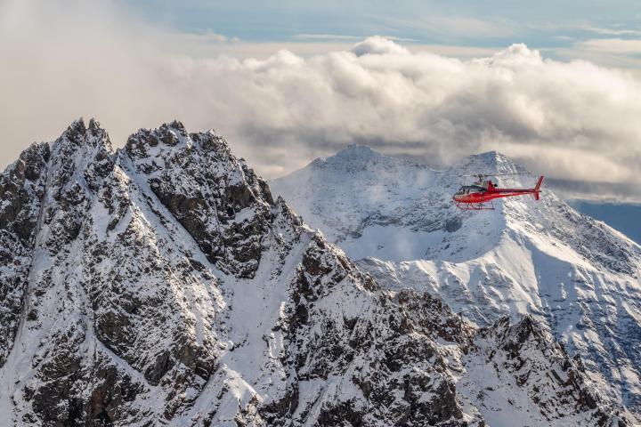 a man flying through the air on a snow covered mountain