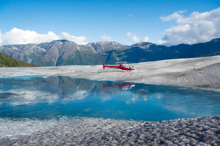 a small boat in a body of water with a mountain in the background