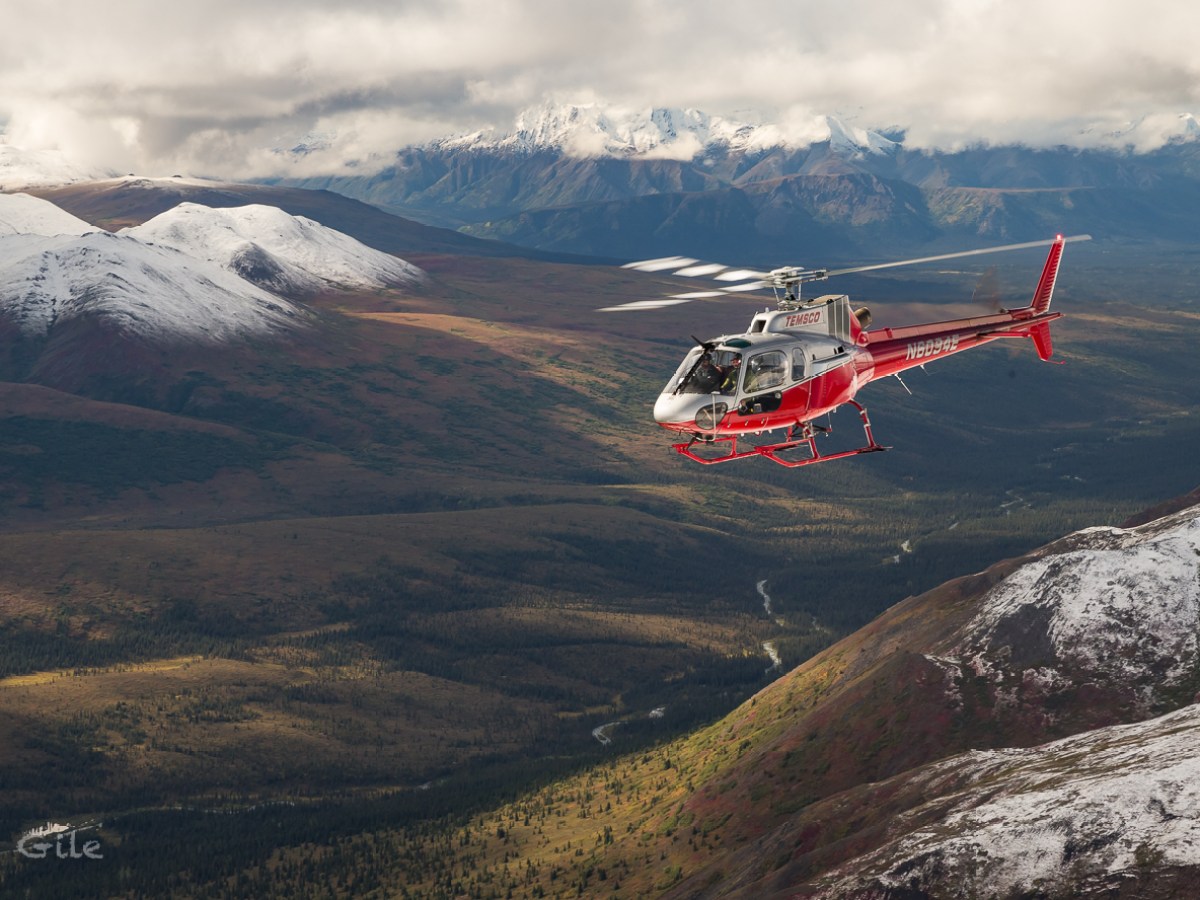 a man flying through the air on top of a mountain