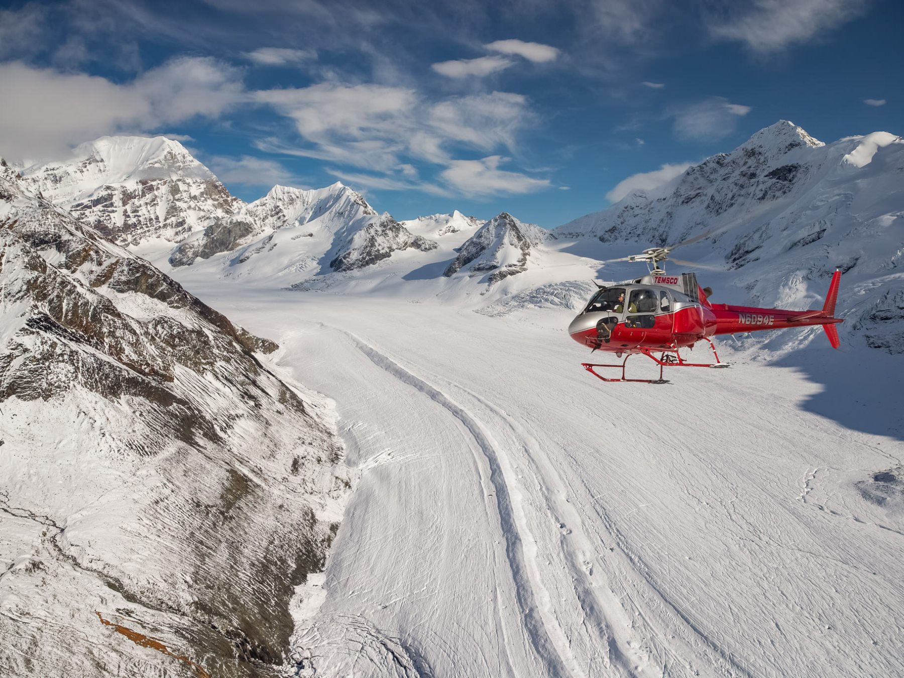 a man riding skis down a snow covered mountain