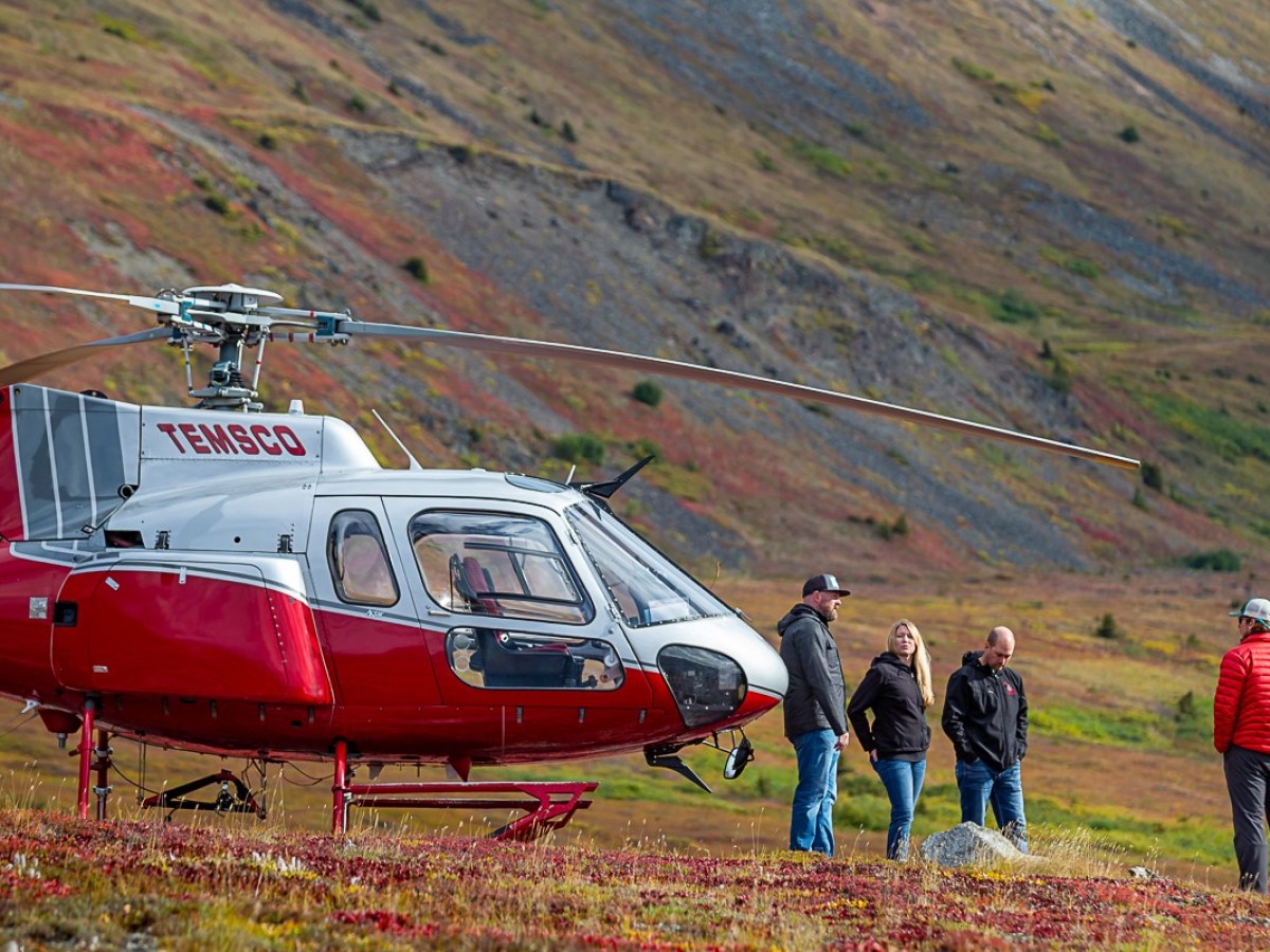 a helicopter parked on a grassy hill
